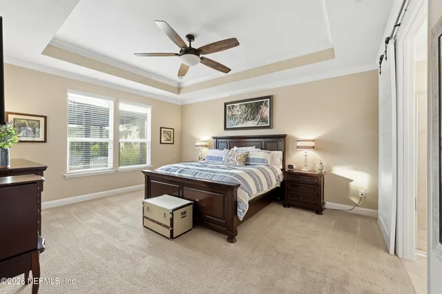 a bedroom with a bed and a mirror on the dresser