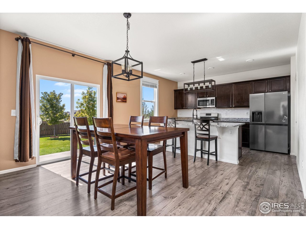 503 Buckrake Street Severance, CO 80550 - Photo 12 of 40 a view of a dining room and livingroom with furniture wooden floor a chandelier