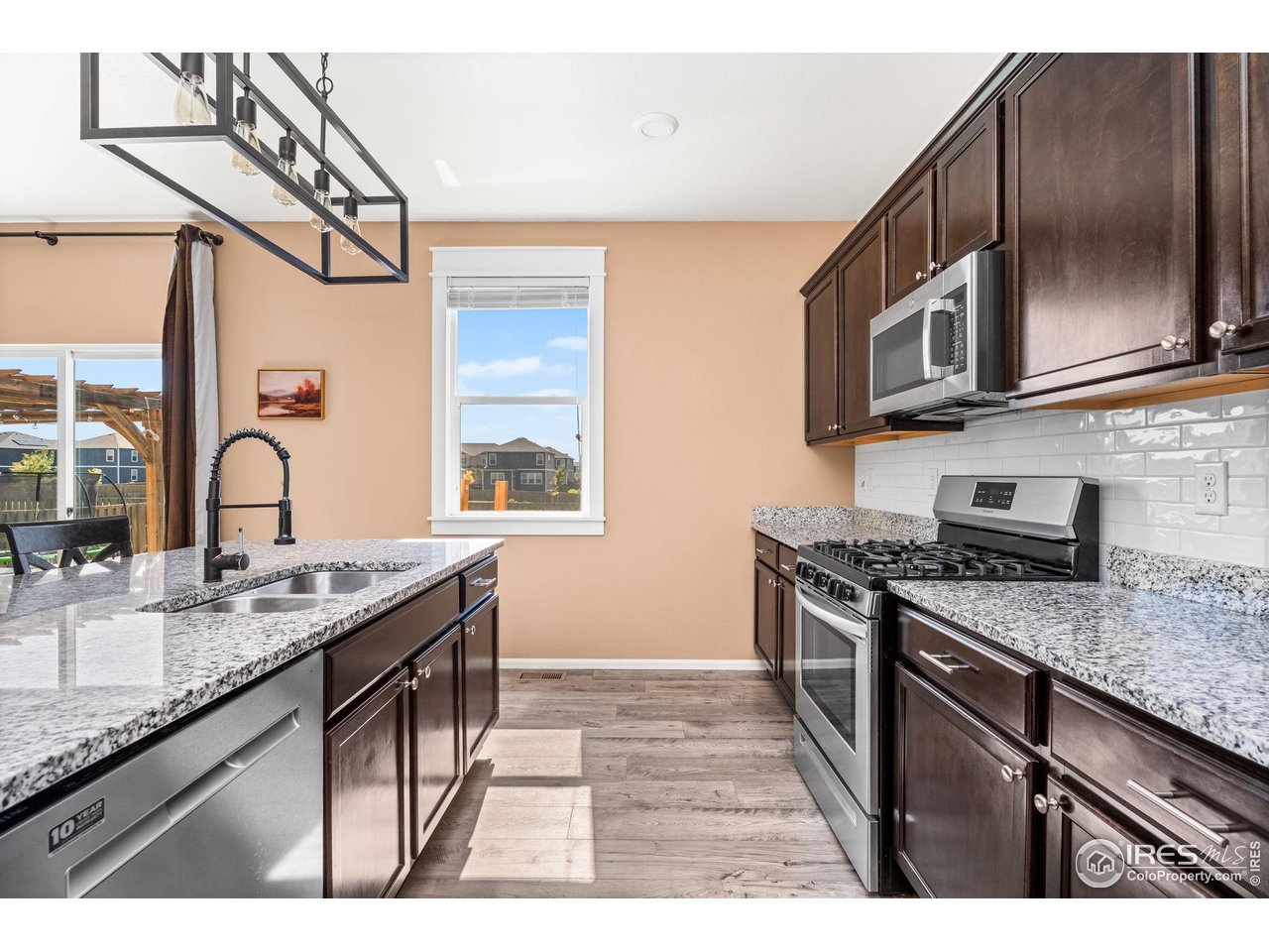 503 Buckrake Street Severance, CO 80550 - Photo 13 of 40 a kitchen with stainless steel appliances granite countertop a sink stove and cabinets