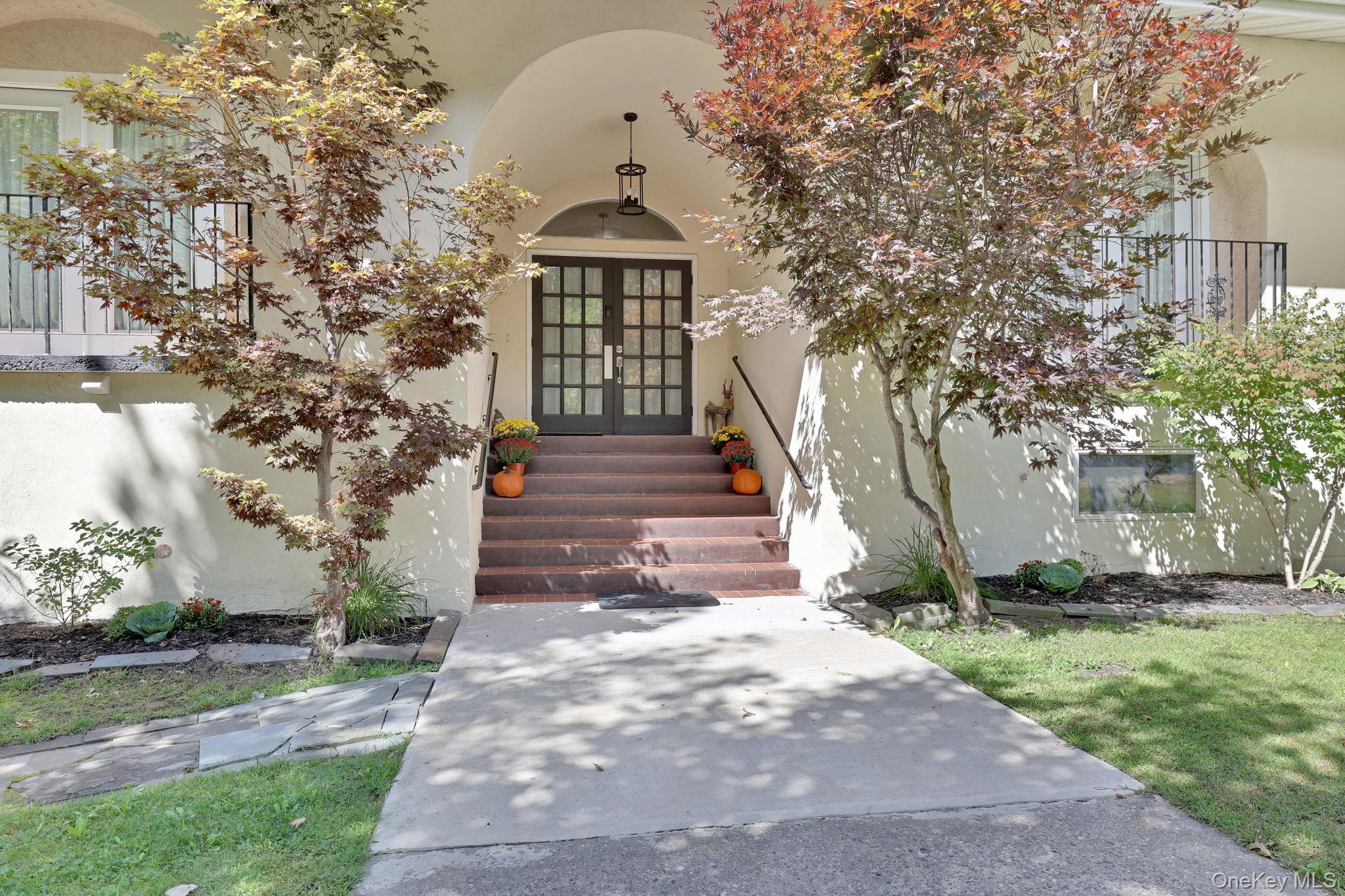23 Cooley Road Parksville, NY 12768 - Photo 1 of 49 Arched entry with double-pane glass doors, complemented by a concrete walkway and mature landscaping