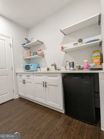 a kitchen with a sink cabinets and wooden floor