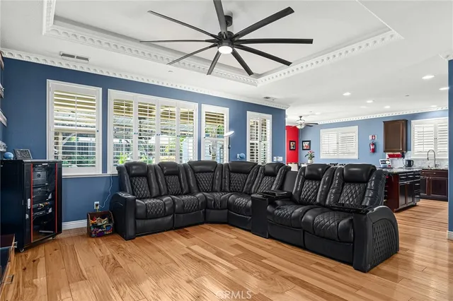 a living room with furniture ceiling fan and a large window