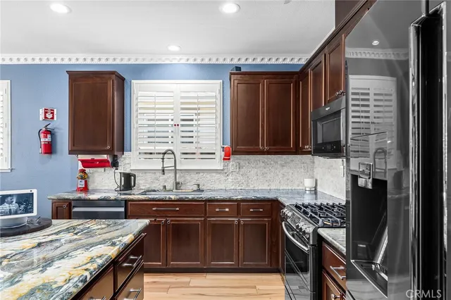 a kitchen with stainless steel appliances granite countertop a sink refrigerator and microwave