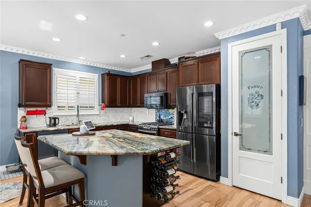 a kitchen with stainless steel appliances granite countertop a sink refrigerator and cabinets
