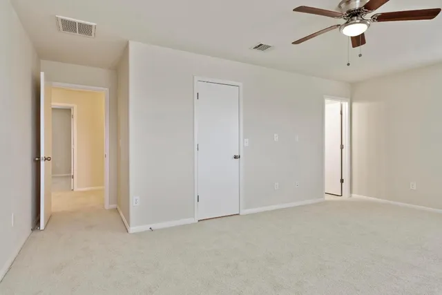 a view of an empty room and a ceiling fan