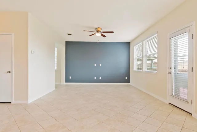 an empty room with windows and fan