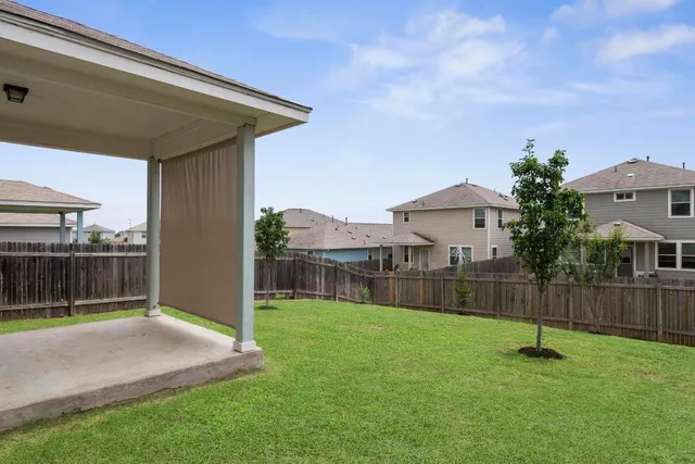 a backyard of a house with table and chairs