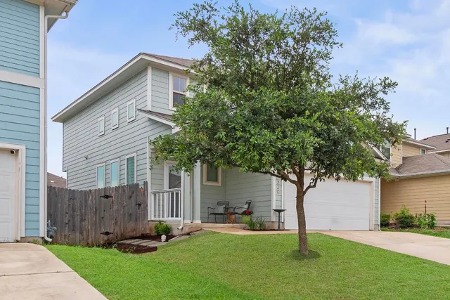 front view of a house with a yard and an trees