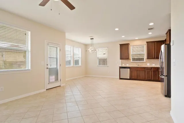 a view of a kitchen with kitchen island granite countertop a sink cabinets and stainless steel appliances