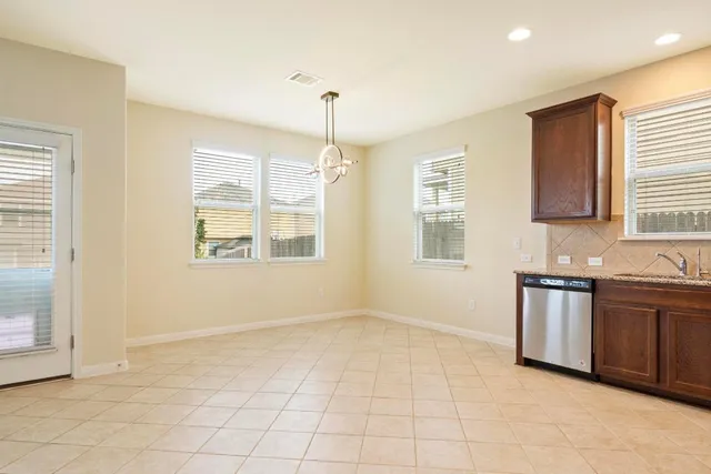 a view of an empty room with window and cabinet
