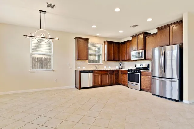 a kitchen with stainless steel appliances granite countertop a refrigerator sink and cabinets