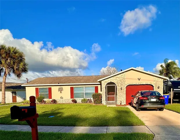 a view of a white house with a big yard and couches chairs