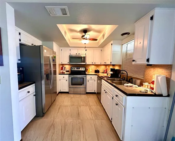 a kitchen with stainless steel appliances granite countertop a refrigerator a stove and a sink