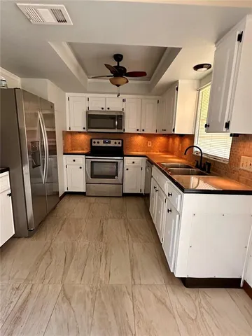 a kitchen with stainless steel appliances granite countertop a sink a stove and a refrigerator