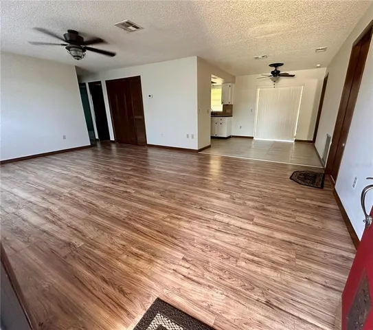 a view of a livingroom with wooden floor and stairs