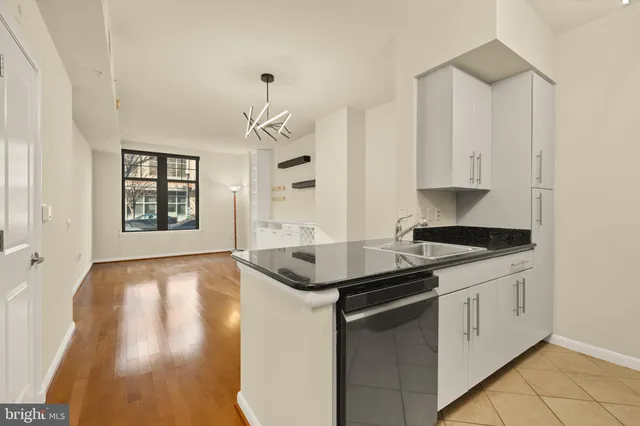 a kitchen with stainless steel appliances granite countertop a sink and a stove with white countertops