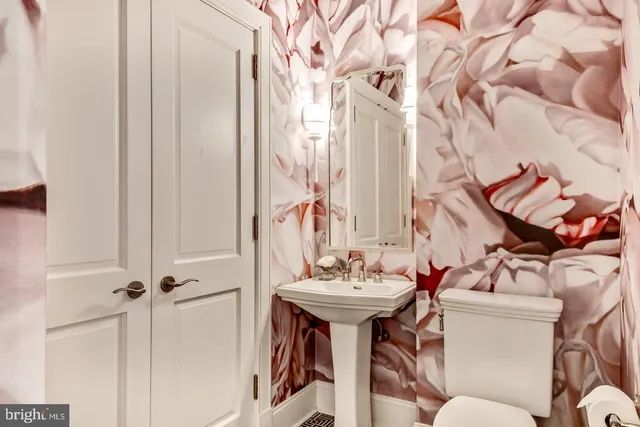 a bathroom with a sink and mirror with toilet