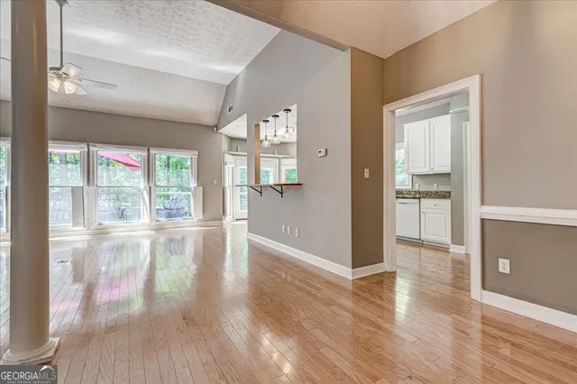an empty room with wooden floor and windows