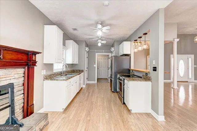 a kitchen with granite countertop a refrigerator oven stove top oven and sink