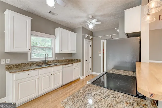 a kitchen with stainless steel appliances granite countertop a stove cabinets and wooden floor