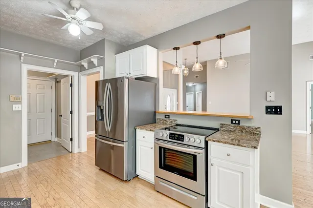 a kitchen with stainless steel appliances a refrigerator and a chandelier