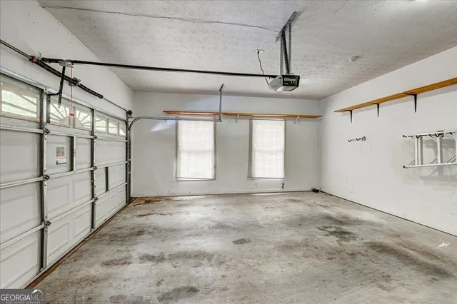 a view of an empty room with wooden floor and a ceiling fan