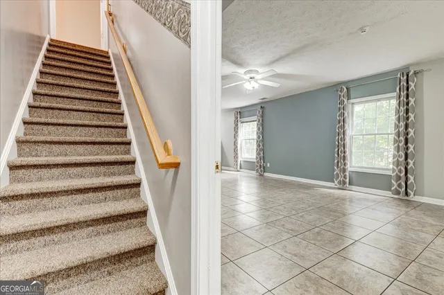 a view of an empty room with a chandelier fan