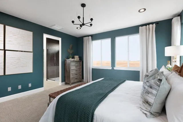 a bedroom with a large bed and a chandelier