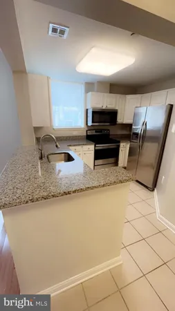 a kitchen with stainless steel appliances granite countertop a sink and a stove
