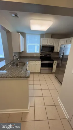 a kitchen with granite countertop a stove a sink and a microwave