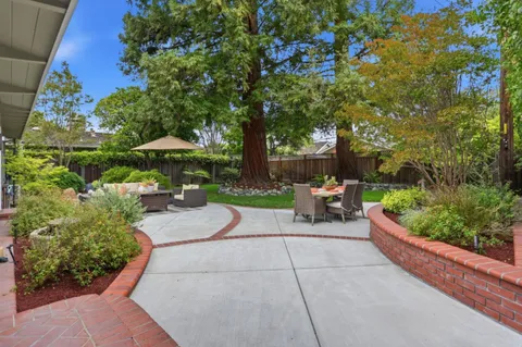 a view of a house with backyard sitting area and garden
