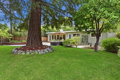 a view of backyard with outdoor seating and green space