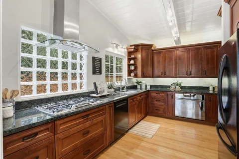 a kitchen with granite countertop a sink stove and cabinets