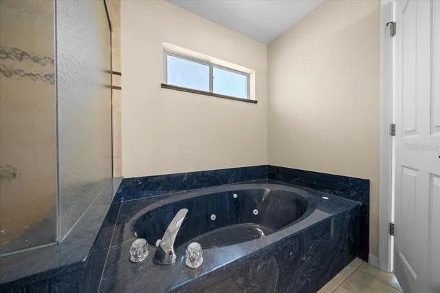 a spacious bathroom with a granite countertop sink a mirror and a shower