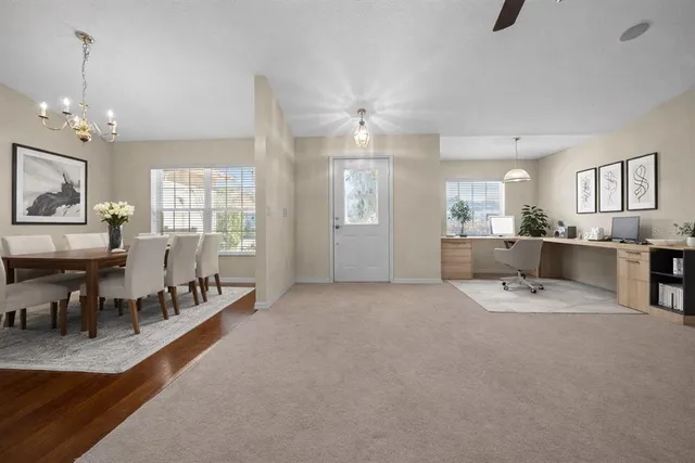 a large living room with stainless steel appliances kitchen island granite countertop furniture and a chandelier