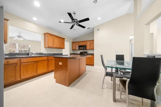 a kitchen with stainless steel appliances kitchen island granite countertop a sink counter space and a window