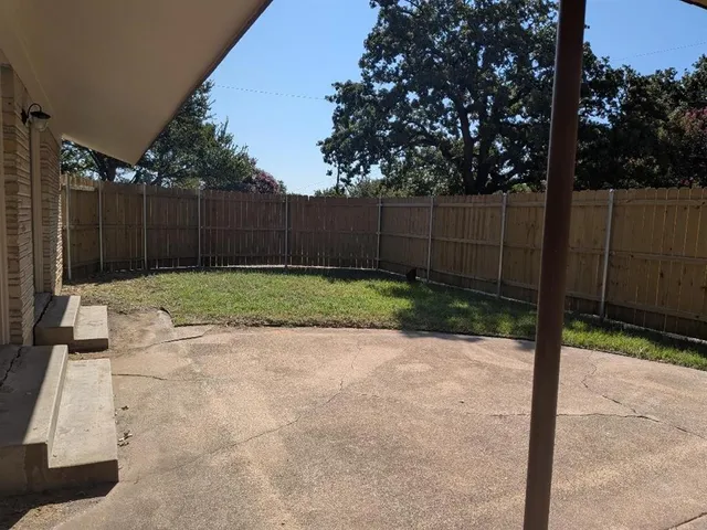 a view of a backyard with wooden fence