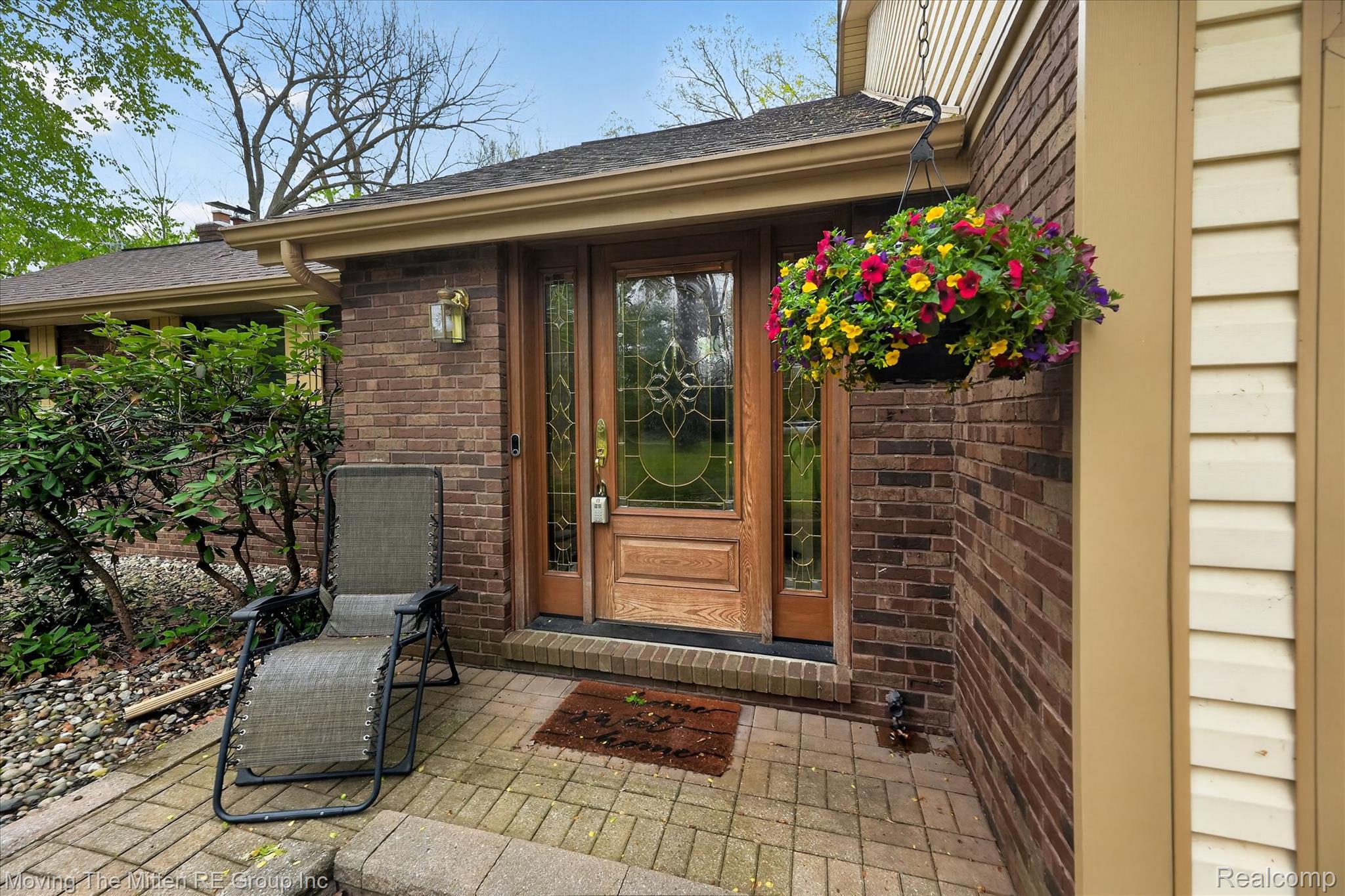 Doorway to property featuring brick siding and a shingled roof
