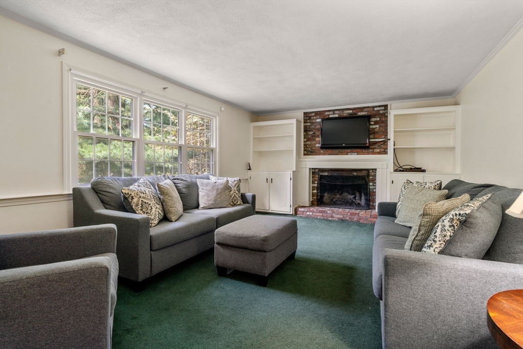 21 Pawnee Circle Milton, MA 02186 - Photo 11 of 17 a living room with furniture a flat screen tv and a fireplace