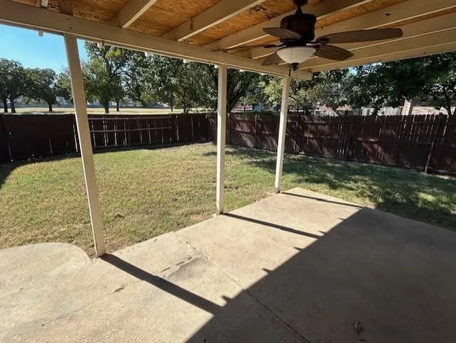 a view of a backyard with floor to ceiling window and wooden fence