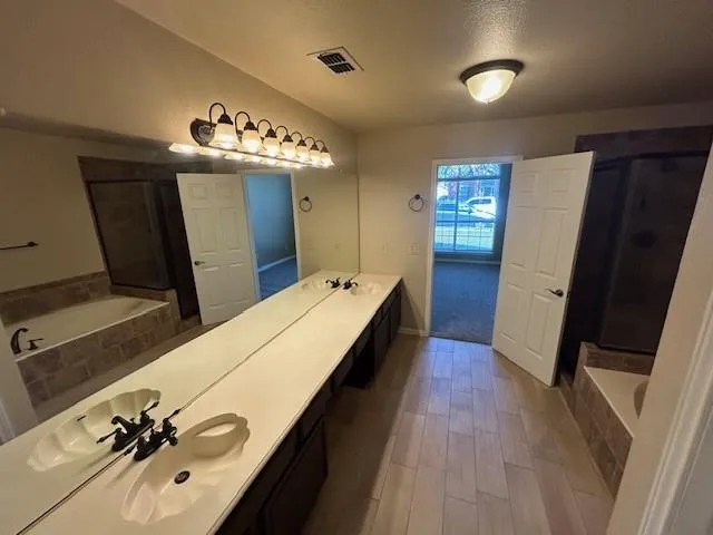 a spacious bathroom with a double vanity sink and a mirror