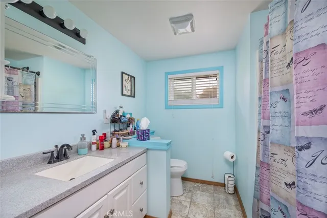 a bathroom with a sink mirror vanity and toilet