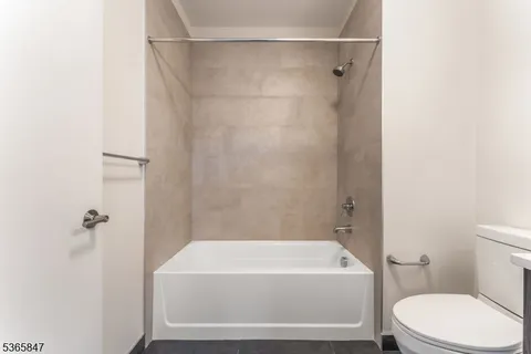 a bathroom with a white bath tub a toilet and a sink