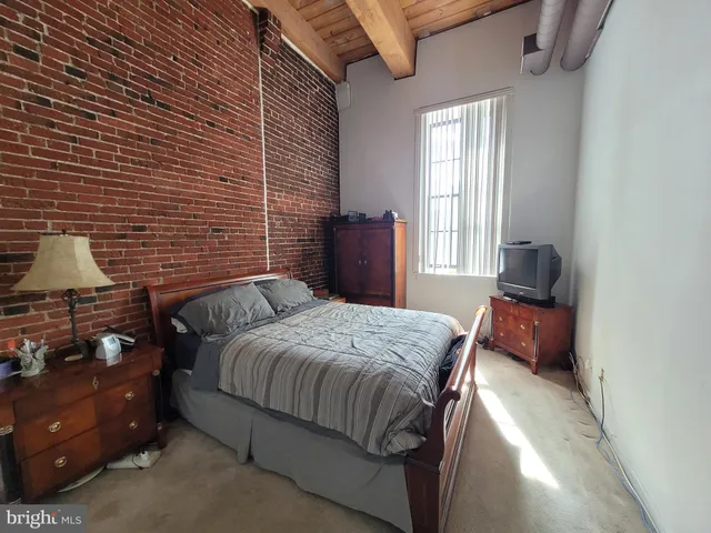 a bedroom with a bed and a flat tv screen