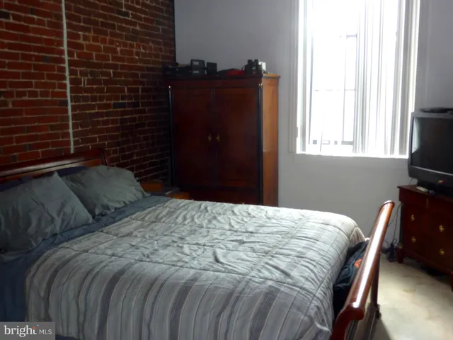 a bedroom with a bed and a flat tv screen