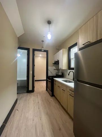a kitchen with a refrigerator a sink and cabinets