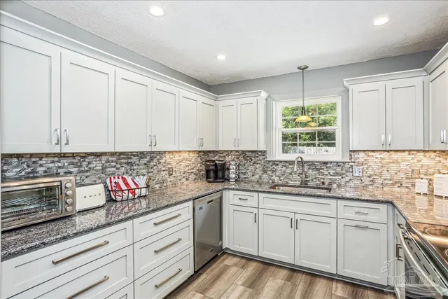 a kitchen with stainless steel appliances granite countertop a sink and cabinets