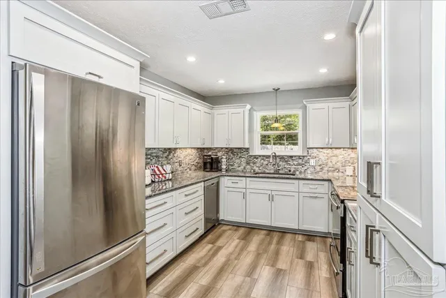 a kitchen with granite countertop cabinets appliances and a counter top space