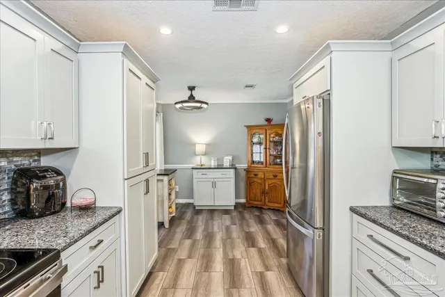 a kitchen with white cabinets and appliances