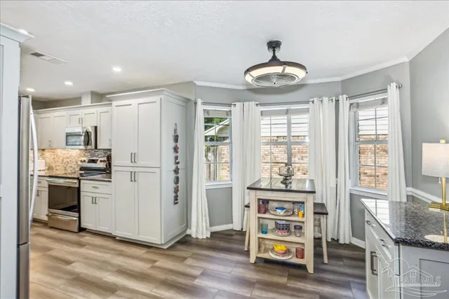 a room with stainless steel appliances granite countertop a stove and a refrigerator